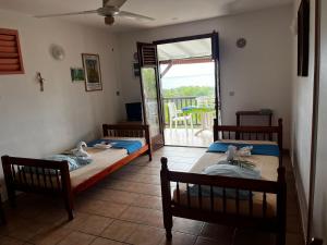 two beds in a room with a balcony at rose de jericho in Deshaies