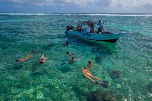 a group of people in the water next to a boat at Coba Belize in San Pedro