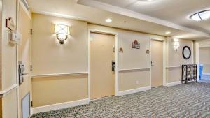 a large hallway with doors and a clock on the wall at Oceanfront Studio in Daytona Beach Resort in Daytona Beach