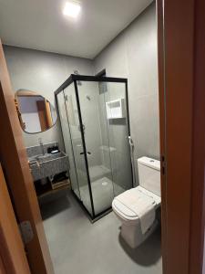 a bathroom with a shower and a toilet and a sink at Villa Naluri - Casa Auati - Apart 2 Quartos -Vista Mar in Japaratinga