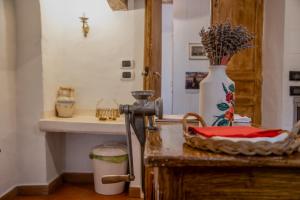 a kitchen with a table with a vase on it at Casa Lanzara - Dimora Storica nel cuore del Pollino in Morano Calabro +92 photos