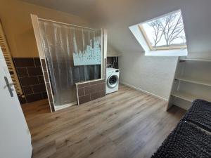 a laundry room with a washing machine and a window at La perle des Lacs in Dompierre-sur-Mont