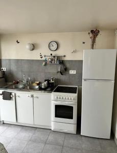 a kitchen with a white stove and a refrigerator at Petite maison calme dans un jardin in Bois-Colombes +8 photos
