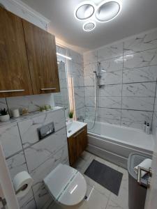 a bathroom with a toilet and a tub and a sink at ONYX - Vision Aparthotel in Braşov +25 photos