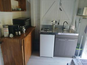 a small kitchen with a sink and a stove at Bungalow Lolo Moringa in Bouillante +3 photos