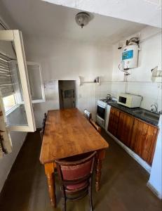 una cucina con tavolo in legno e forno a microonde di Los Lirios Gardes Pehuajo a Pehuajó