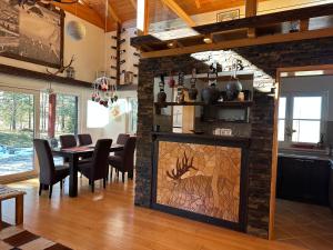 a dining room with a fireplace with a table and chairs at Planinska kuća Ema in Kupres