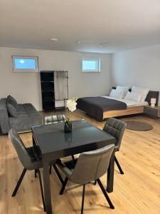 a living room with a bed and a table and chairs at Neues Haus, stadtnah in Gerasdorf bei Wien
