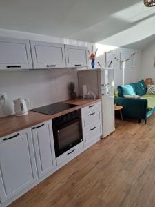 ŻarnowskaにあるApartament Piaskowa 2の白いキャビネットと冷蔵庫のあるキッチン