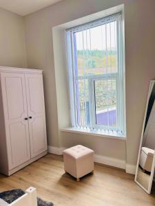 a room with a large window and a white cabinet at Seafront Apartment in Newcastle +11 photos