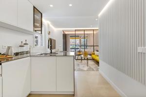 a kitchen with white cabinets and a living room at Golden Mile Lux Sea View Suite with Balcony in Marbella