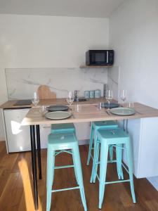 a kitchen with a table with two blue stools at appartement la boheme, Disney 15 min, Paris 25 min in Thorigny-sur-Marne