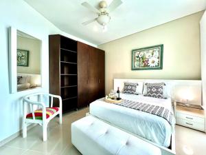 a bedroom with a white bed and a chair at Emmaus in Cartagena de Indias +39 photos