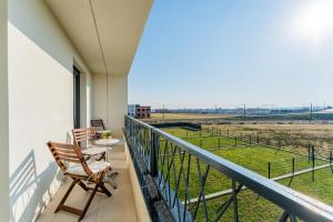 a balcony with chairs and a table and a view of a field at Flex SelfCheckIns 143 - Novaki -Terrace - 4 Bedrooms - Parking in Novaki Samoborski