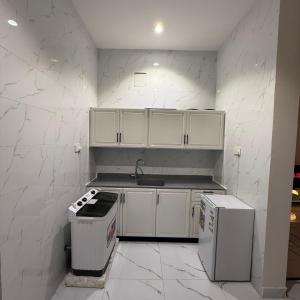 a kitchen with white cabinets and a sink at شقق منزال 1 in Hafr Al Baten