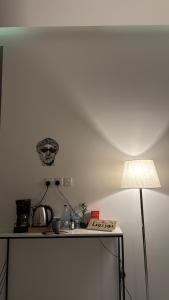 a table with a lamp and a skull on the wall at شقق منزال 1 in Hafr Al Baten