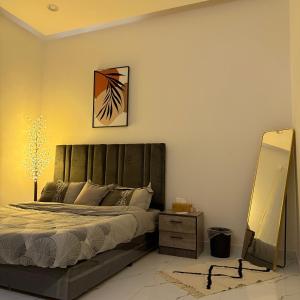 a bedroom with a large bed and a mirror at شقق منزال 1 in Hafr Al Baten