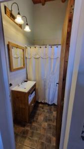 ein Badezimmer mit einem weißen Duschvorhang und einem Waschbecken in der Unterkunft Estancia Helvetia in San José