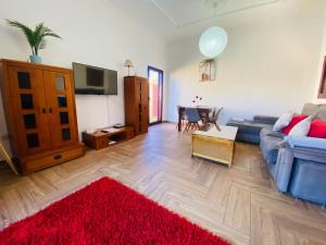 a living room with a blue couch and a red rug at Villa Bejeque & Barbecue in La Oliva
