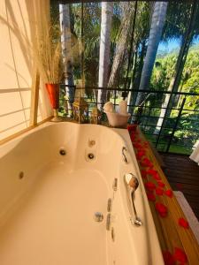 a white bath tub in a room with a window at Pousada L'Amore in Siderópolis