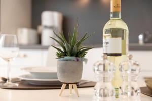 a bottle of wine and a potted plant on a table at NINO-Boardinghouse 20 in Nordhorn