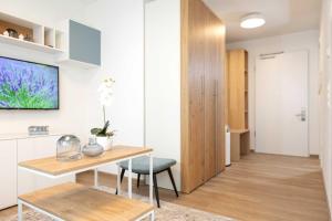 a living room with a table and a tv on a wall at NINO-Boardinghouse 20 in Nordhorn