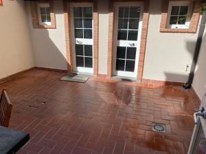 a room with a brick floor and two doors at Art & Family Ideal for families in Viareggio