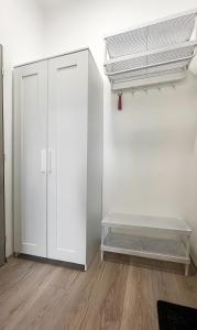 ブルノにあるCotton&Loft - Brno City Center Apartmentの白いキャビネットとファンが備わる客室です。 +5枚の写真