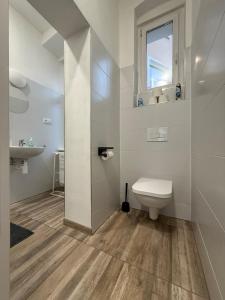 une salle de bain blanche avec toilettes et lavabo dans l'établissement Apartmán Pohoda - dvojlůžkový, v lázeňském centru, à Karlovy Vary