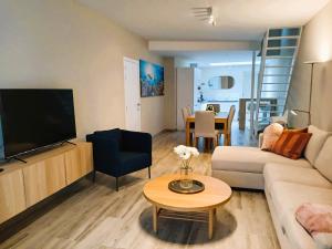a living room with a couch and a tv and a table at EasyEscape - Martha-Louise in Blankenberge
