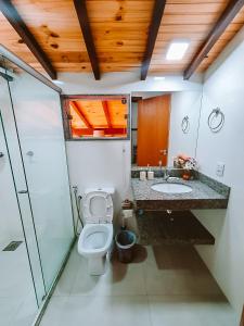 a bathroom with a toilet and a sink at Suítes da Penha in Capitólio