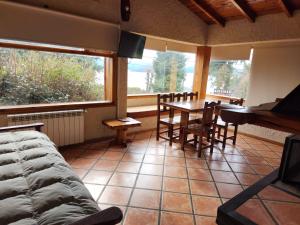 a living room with a table and chairs and a couch at Brisas del Lago in San Carlos de Bariloche