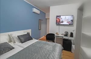 a bedroom with a bed and a desk with a television at Alloggi Tosca Airport Lodges in Ronchi dei Legionari