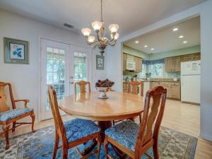 ヒルトン・ヘッド・アイランドにあるEvian 123の木製のテーブルと椅子のあるキッチンとダイニングルーム