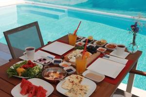 a table with food and drinks next to a swimming pool at Venezia Alaçatı in Yumru