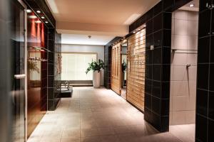 un corridoio di un bagno con piastrelle nere di Novotel Karlsruhe City a Karlsruhe