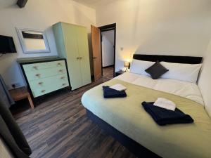 a bedroom with a large bed with two towels on it at Penrhyn Cottage in Penrhyn Bay
