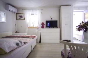 a bedroom with a bed and a tv on a dresser at House Marie?s Lavander Dream in Raslina