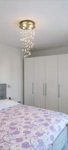 a bedroom with a large bed and a chandelier at House Marie?s Lavander Dream in Raslina