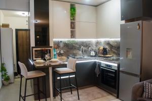 una cucina con lavandino e bancone con sgabelli di Nelly's Place 10 a Shkorpilovtsi