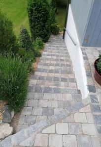 a stone walkway in a yard with a house at Ferienwohnung Perschl in Waging am See