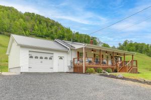a white house with a porch and a garage at Hike and Relax Blue Ridge Mountain Retreat! in Burnsville