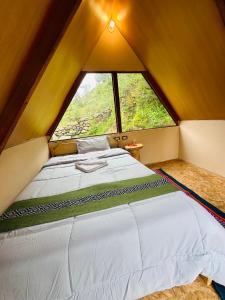 a large bed in a room with a large window at Salkantay Glamp in Colcapampa