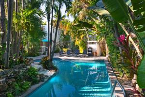 a swimming pool in a resort with palm trees at Westwinds Inn in Key West