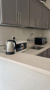 a kitchen counter with a tea kettle and a sink at فيلا مصغره بكراج سياره وفناء خاص in Khamis Mushayt +11 photos