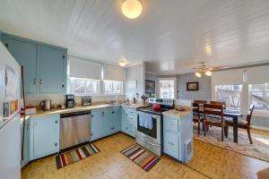 a kitchen with blue cabinets and a dining room at Cozy Augusta Home with Porch Walk to Katy Trail! in Augusta +16 photos