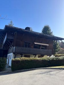 a wooden house with a porch and a balcony at Confort et Proximité in Megève