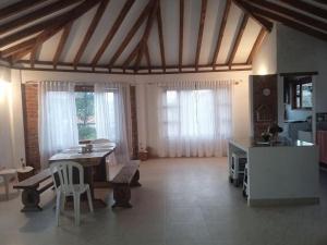 ein Wohnzimmer mit Tisch und Stühlen und Fenstern in der Unterkunft Casa Linda in Villa de Leyva + 25 Fotos
