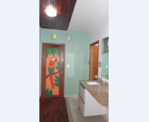 a bathroom with a colorful painting on the door at Ajuricaba Suítes 7 in Manaus