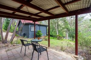 un patio con tavolo, sedie e una casa di Romantic Tricklebeck Spa Cottage a Blackheath